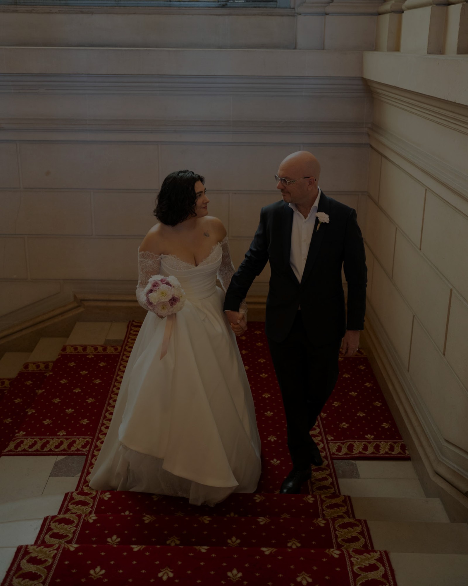 Daren et Sarah se tenant la main dans un escalier, le jour de leur mariage